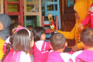 Ibu guru menyerahkan piala